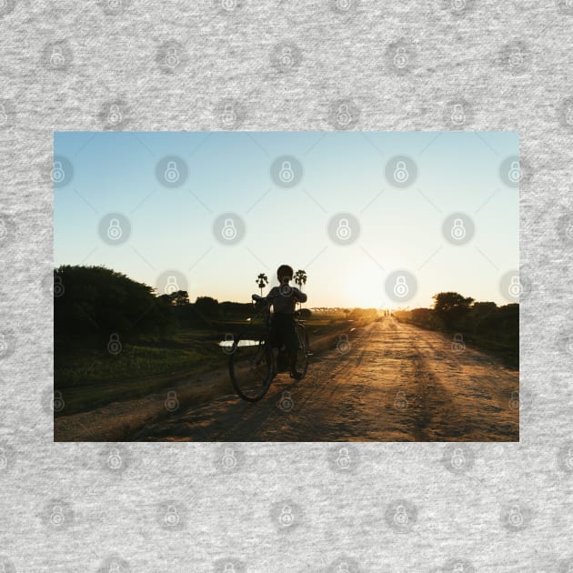 Silhouette of Boy Riding Bicycle at Sunset in Burmese Countryside by visualspectrum